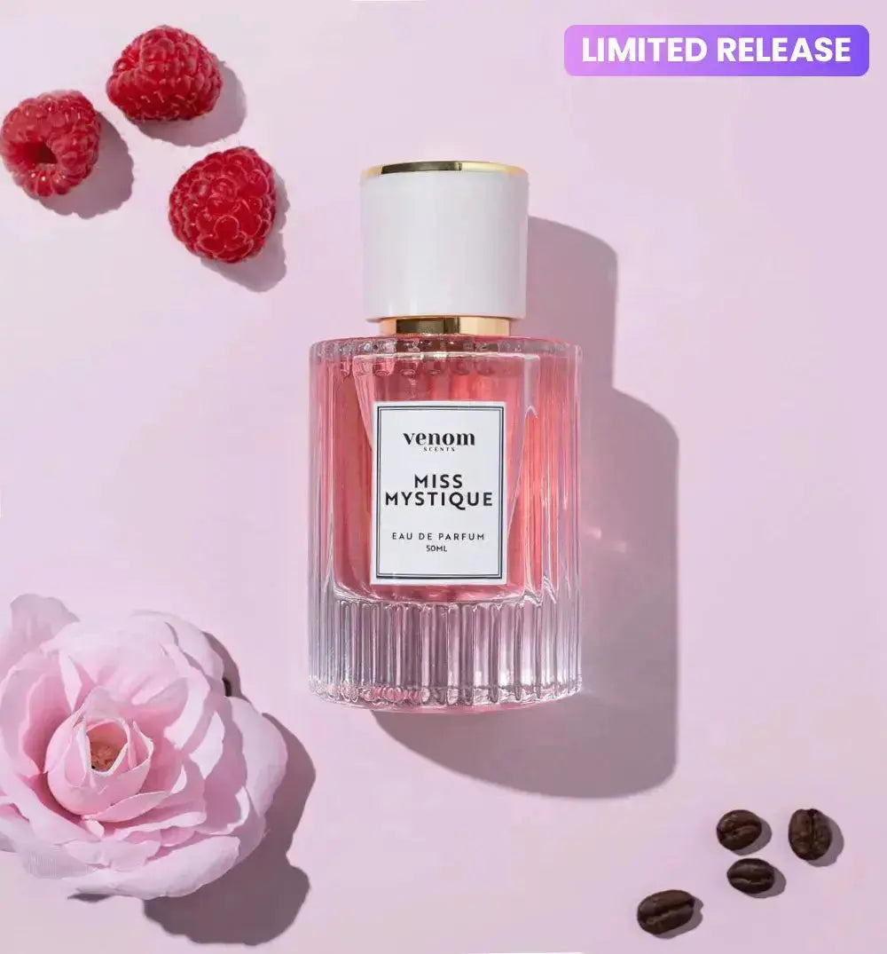 Perfume bottle with raspberries, pink rose, coffee beans; labeled 'Miss Mystique' and 'Limited Release.'